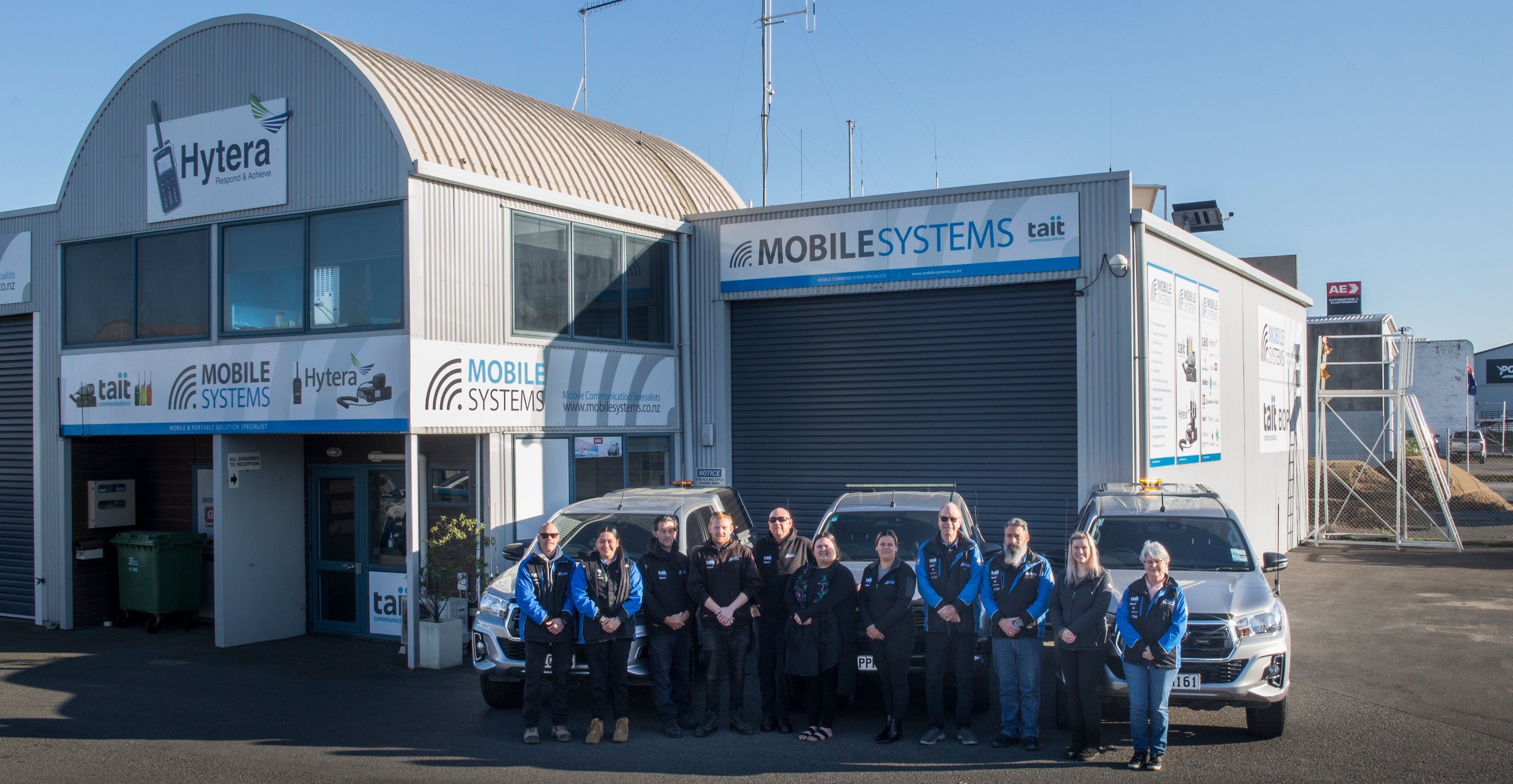 Collection of Mobile Systems Limited Team outside of workshop in a gallery layout