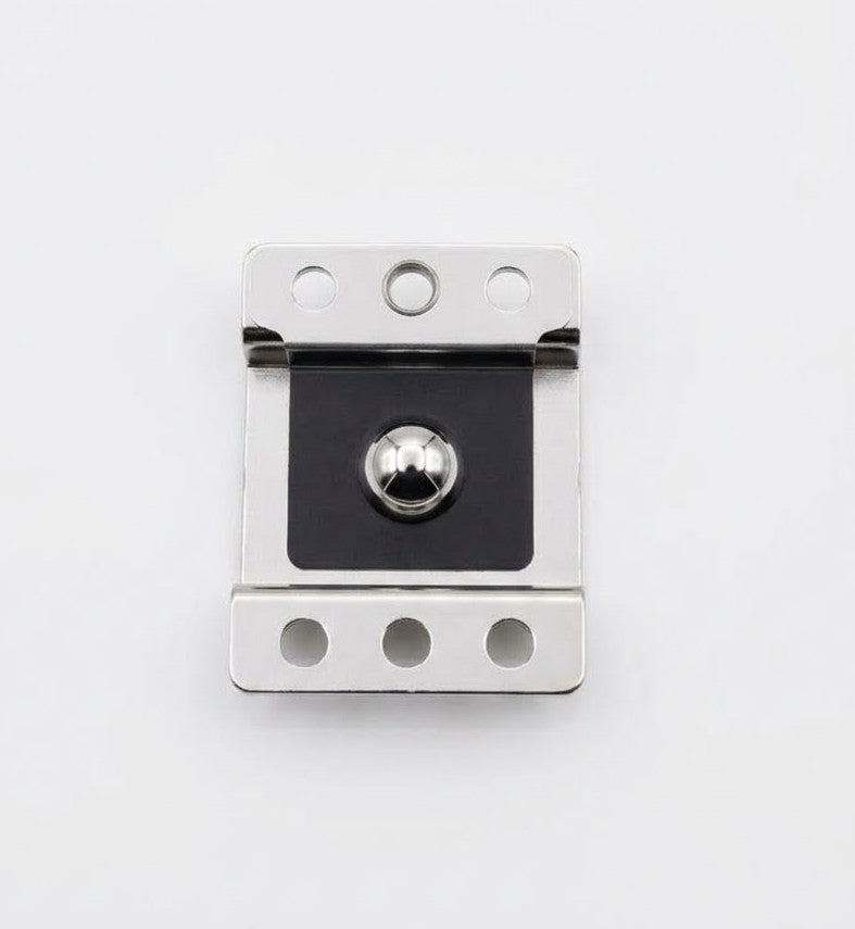 Collection of A close-up of a metal door stopper or latch component with a polished silver finish and a black central plate in a gallery layout
